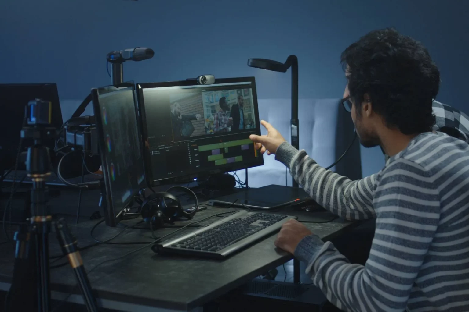 Two people editing video for filmmaking on the computer in the studio